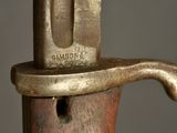 a close up of a sword with a metal handle on a gray background