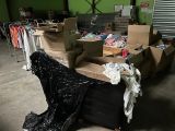 une pile de cartons et de vêtements posée sur un carton dans un entrepôt
