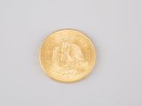 a close up of a gold coin on a white surface