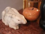 marble sculpture of a polar bear sitting on a table next to an apple