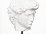 marble bust of a young man with curly hair on a marble base