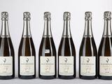 six bouteilles de vin sont alignées sur une table