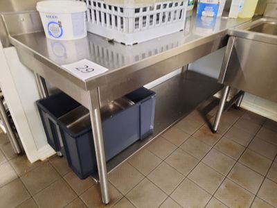 a stainless steel table with a basket on top of it