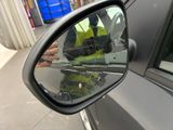 a reflection of a man in the side view mirror of a car