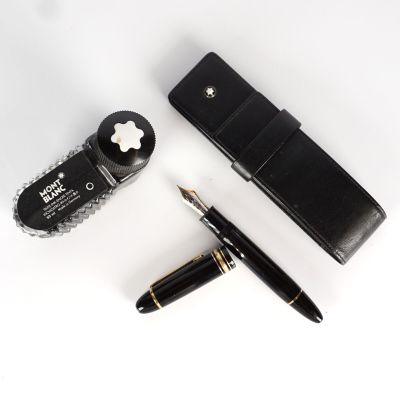 le stylo se trouve à côté d'un étui à stylos et d'un stylo posé sur une surface blanche