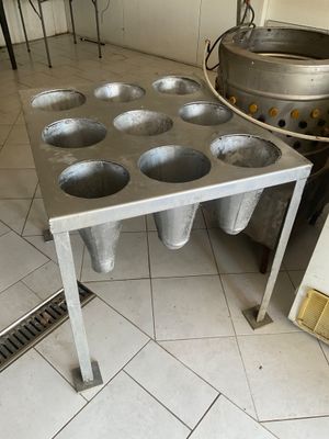 stainless steel muffin pans on a table in a commercial kitchen