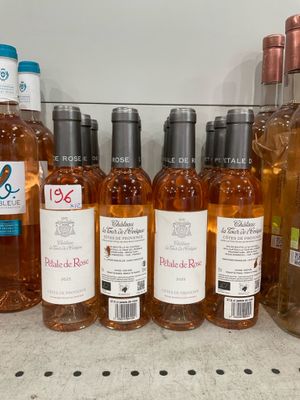 bottles of wine are lined up on a shelf in a store
