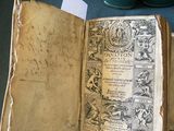 un livre ouvert sur une table, avec plusieurs livres en arrière-plan