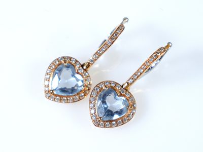 une paire de boucles d'oreilles en topaze bleue et diamants sur fond blanc