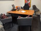 a desk with two chairs and a laptop on top of it