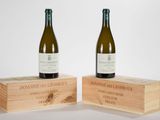 deux bouteilles de vin posées l'une à côté de l'autre sur des caisses en bois