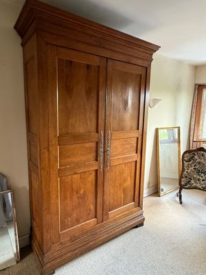 une grande armoire en bois dans le coin d'une pièce