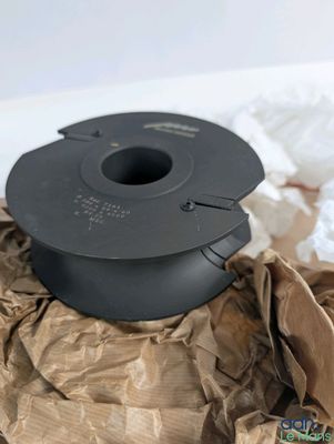 a black spool sitting on a brown piece of paper
