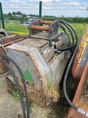 une machine posée par terre à côté d'une clôture
