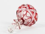 a red and white ornament on a white surface