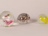 three glass marbles sitting on top of a table next to each other