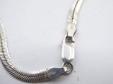 silver plated snake chain with a clasp on a white surface