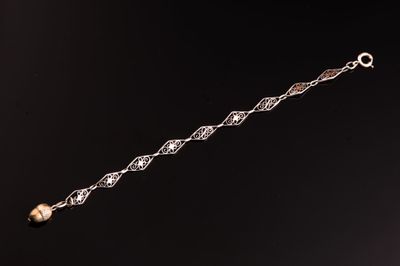 un gros plan d'un bracelet en argent orné d'une perle