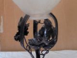 une lampe posée sur un lit, avec un petit mot rose
