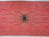 un vieux tapis rouge et noir orné d'un motif