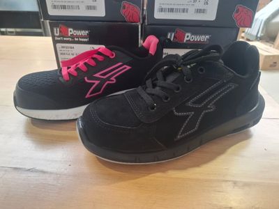 pair of black and pink sneakers sitting on top of a wooden table