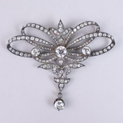 un gros plan d'une broche en diamant posée sur une surface blanche