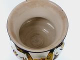 a white vase with a chain handle on it