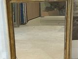 a mirror that is sitting on the floor in front of a wall
