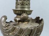 a silver vase with a bird on top of it