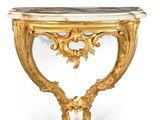 a gold console table with a marble top