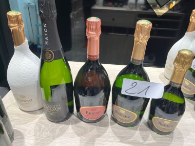 Plusieurs bouteilles de vin sont alignées sur une table, accompagnées d'une étiquette de prix