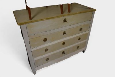 a small chest of drawers with a lamp on top of it