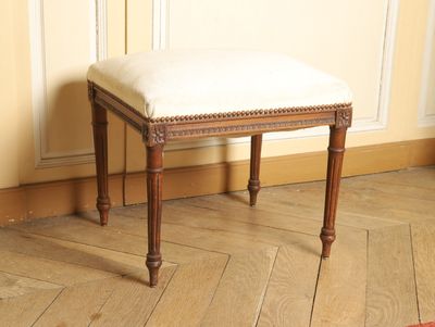 un petit banc en bois sur lequel est posé un coussin blanc