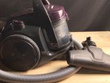 un aspirateur posé sur une table, muni d'un tuyau