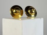 pair of gold plated earrings on a white marble block