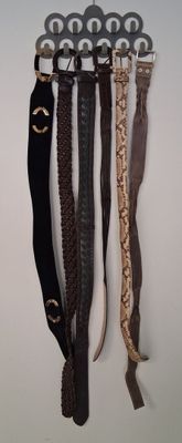 quatre ceintures accrochées à un crochet au mur