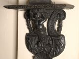 a wall sconce that has a statue on top of it