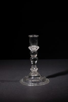 a glass candle holder sitting on a black table