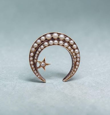 un gros plan sur un croissant en or orné de perles et d'une étoile