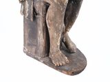 statue of a man sitting on a chair with a book in his lap