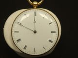 une petite horloge blanche avec des chiffres romains