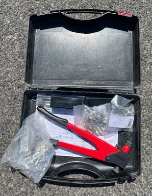 a tool in the case on the ground next to a piece of paper