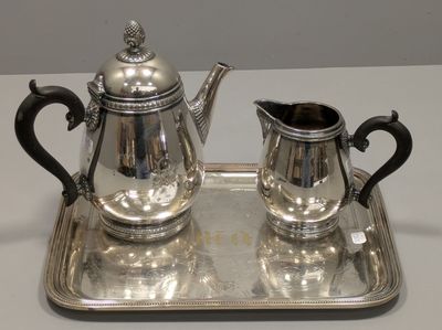 un plateau en argent sur lequel se trouvent une théière en argent et un pichet en argent