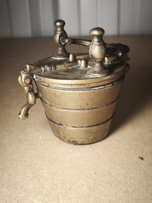 a small metal container with a handle on a table