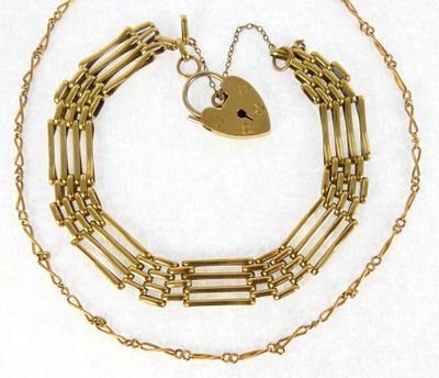 a close up of a gold chain with a heart on it