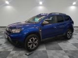 Une Dacia bleue est garée dans une pièce au sol à carreaux.