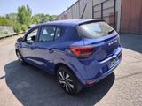 the rear end of a blue car parked in a parking lot