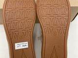 the soles of a pair of brown shoes in a box