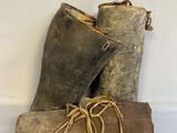 two pairs of old boots sitting on top of a white surface