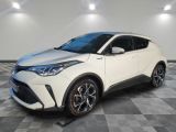 une Toyota C-HR blanche garée dans une pièce au sol à carreaux